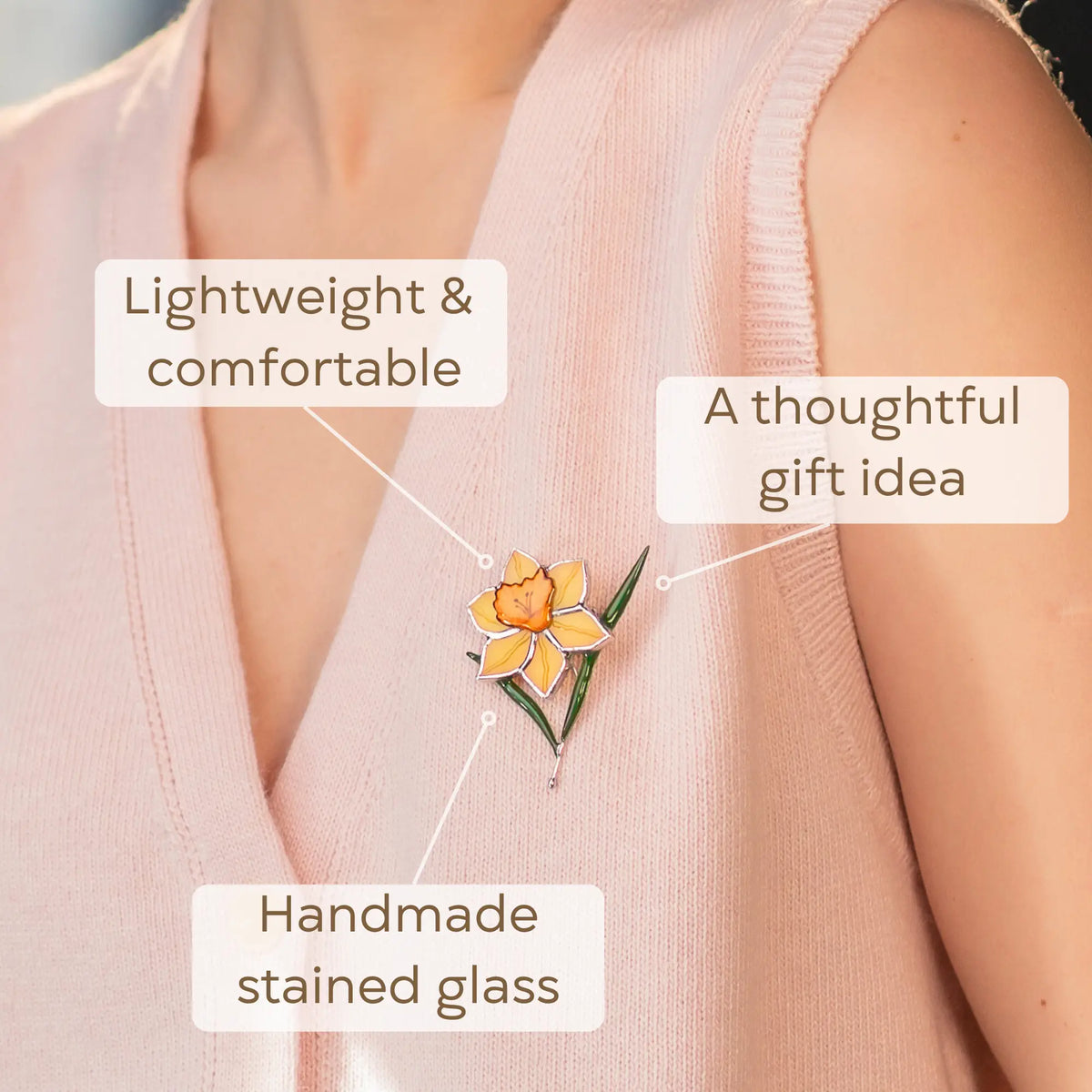 Close-up view of the daffodil stained glass brooch on a pink vest, as a thoughtful gift idea