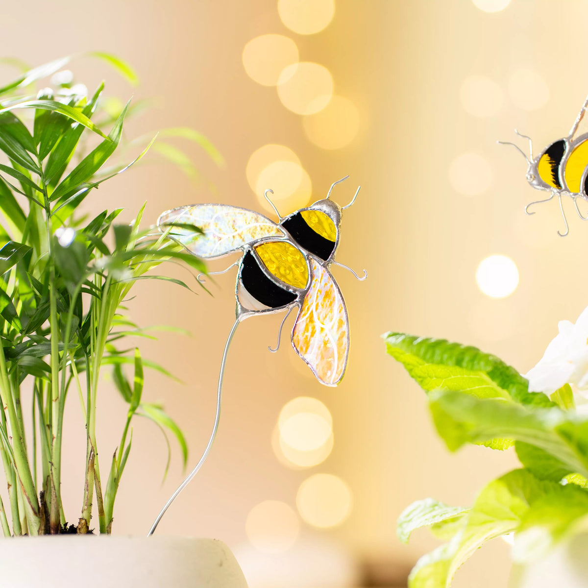 Stained glass bumblebee stake on a blurred background with plants