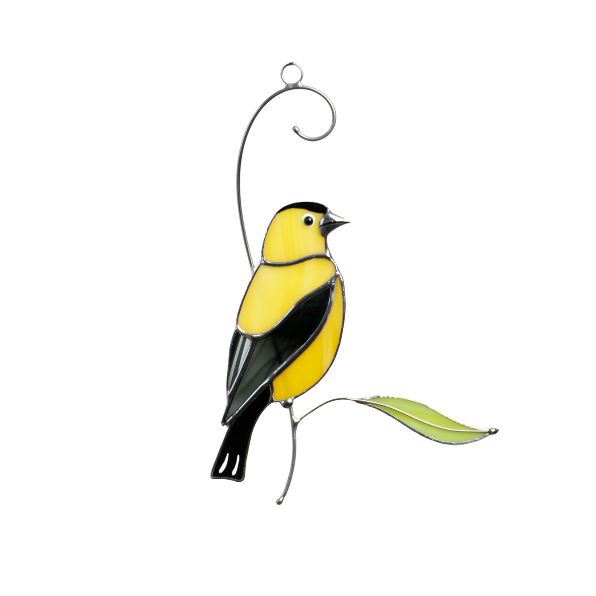 Yellow and black stained glass goldfinch perched with a green glass leaf, perfect for window decor.