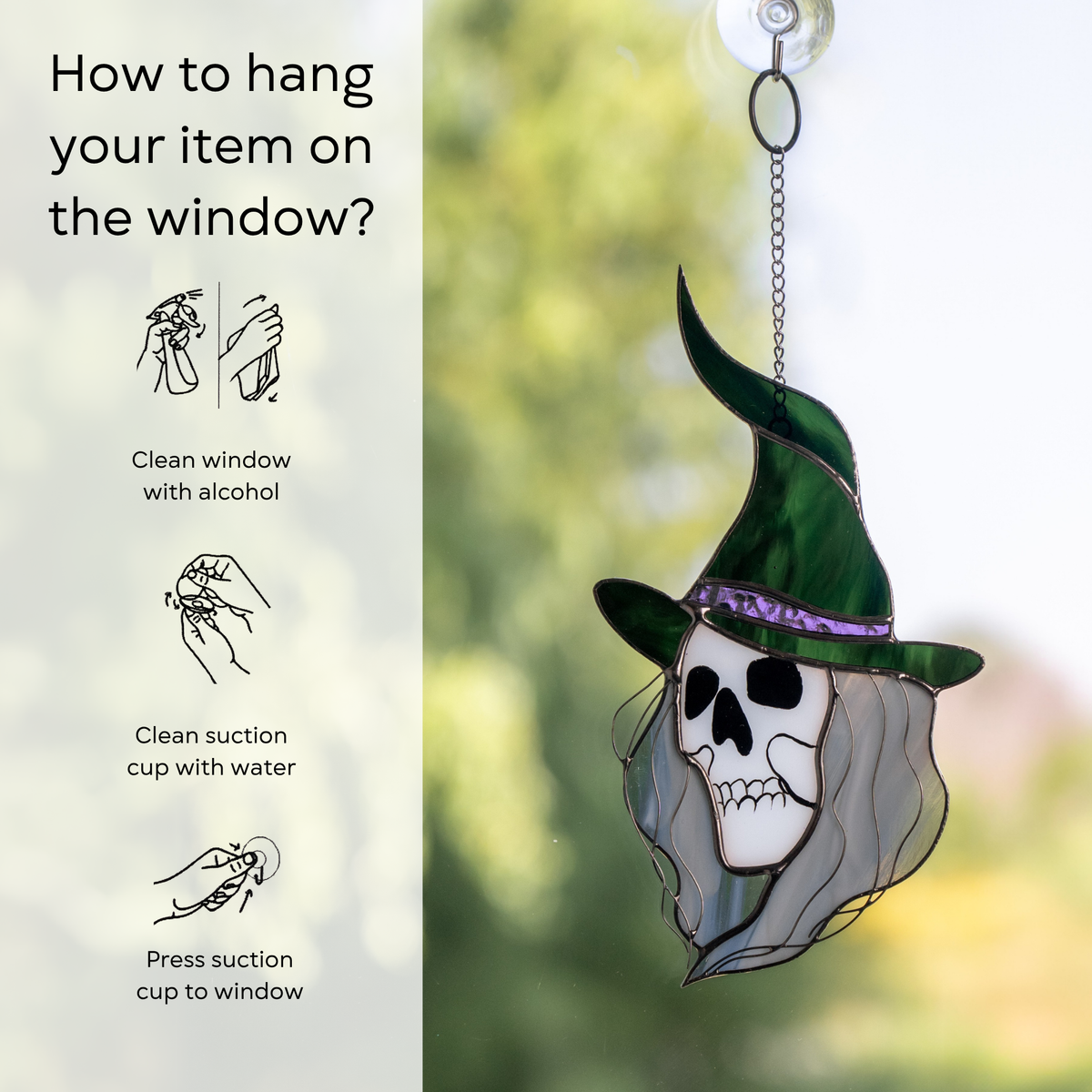 Skull-faced witch with flowing hair and a tall green hat hanging on a window with suction cup and instruction beside: clean window and suction cup, press a cup to the surface