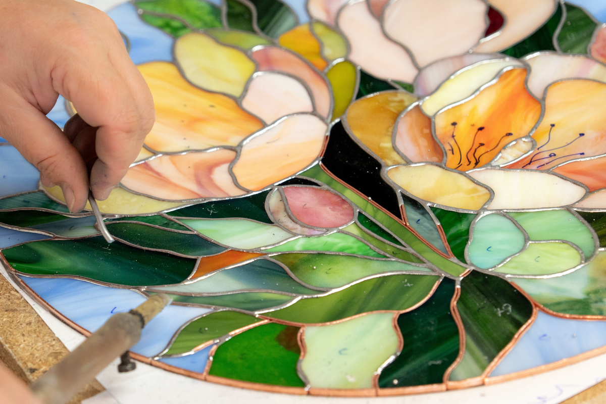 A close-up of a stained glass floral artwork in progress