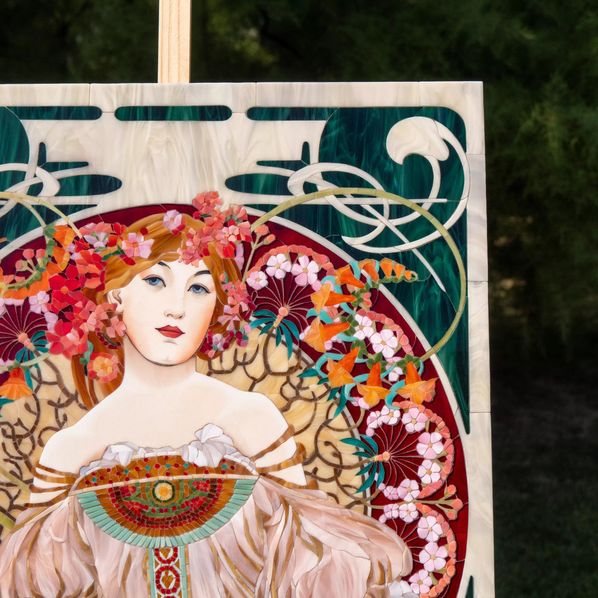 Upper section of Riviera mosaic panel with Art Nouveau curves, deep green glass background, and ornamental flowing lines.