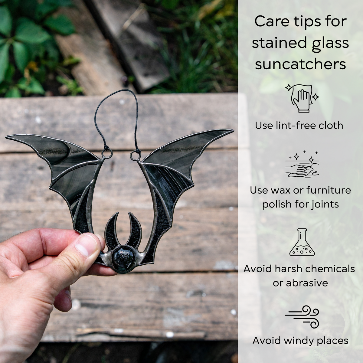 A black bat suncatcher displayed on a wooden surface background with illustrated care tips: use lint-free cloth, polish joints, avoid chemicals and wind.