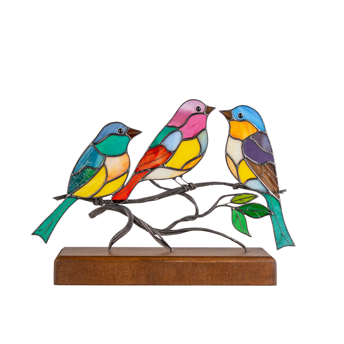 Three colorful stained glass birds perched on a metal branch, set on a brown wooden base against a white background.