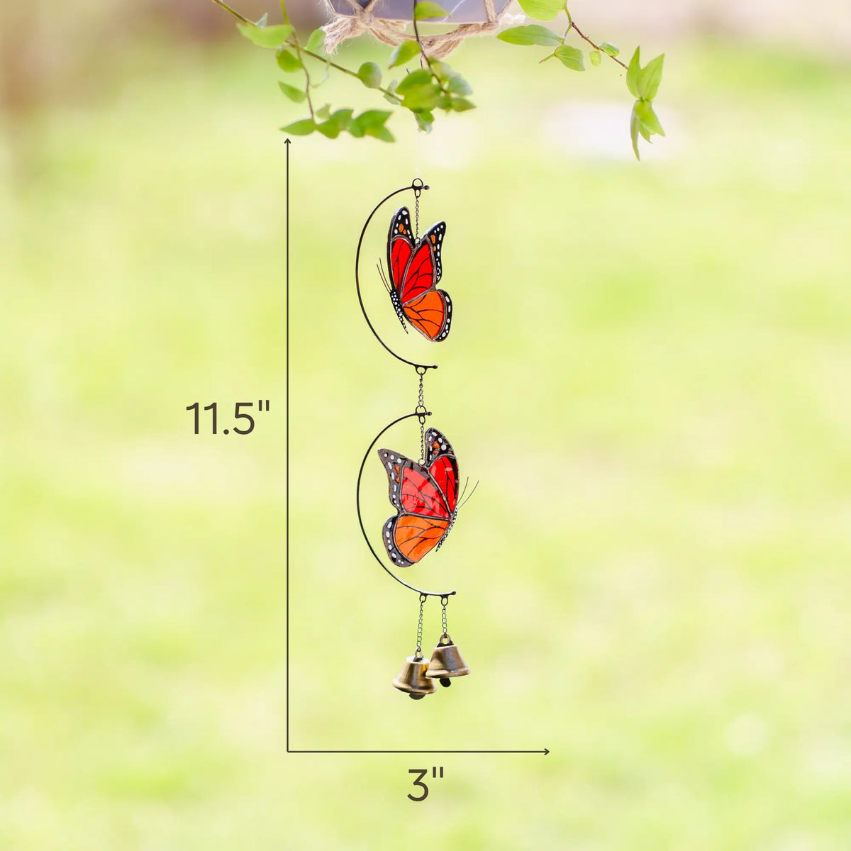 Stained glass butterfly wind chime measuring 11.5 inches tall and 3 inches wide against a blurred green background.
