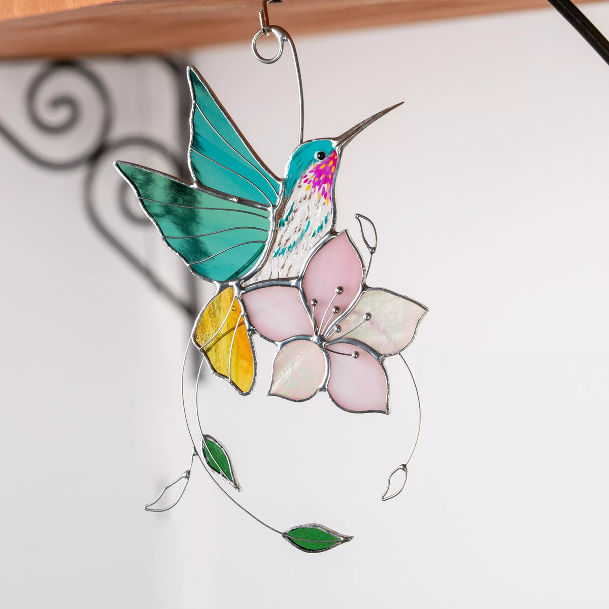 Stained glass hummingbird and flower suncatcher on a white background