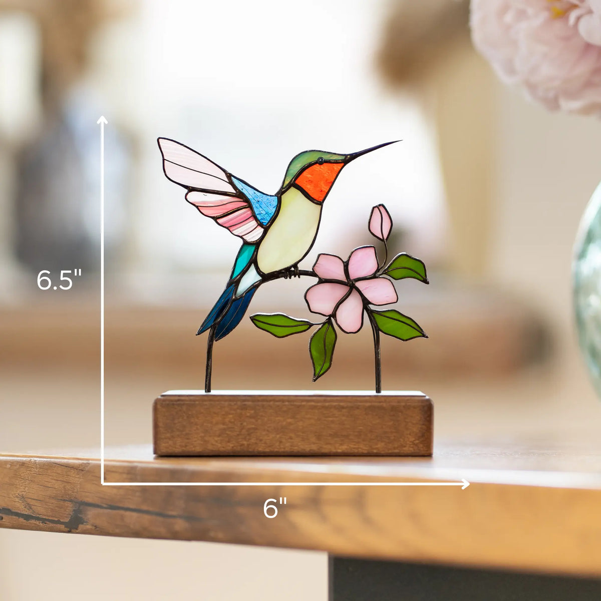 Decorative stained glass hummingbird and flower suncatcher on a wooden base with measurements 6.5 x 6 inches