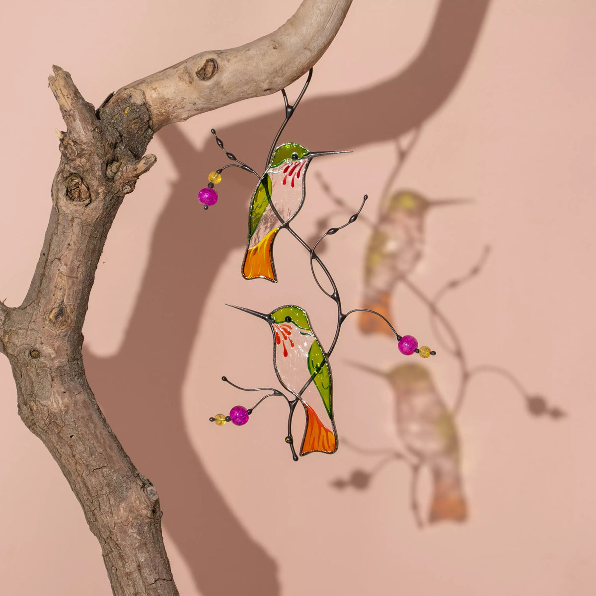 Stained glass suncatcher featuring hummingbirds sitting on a branch