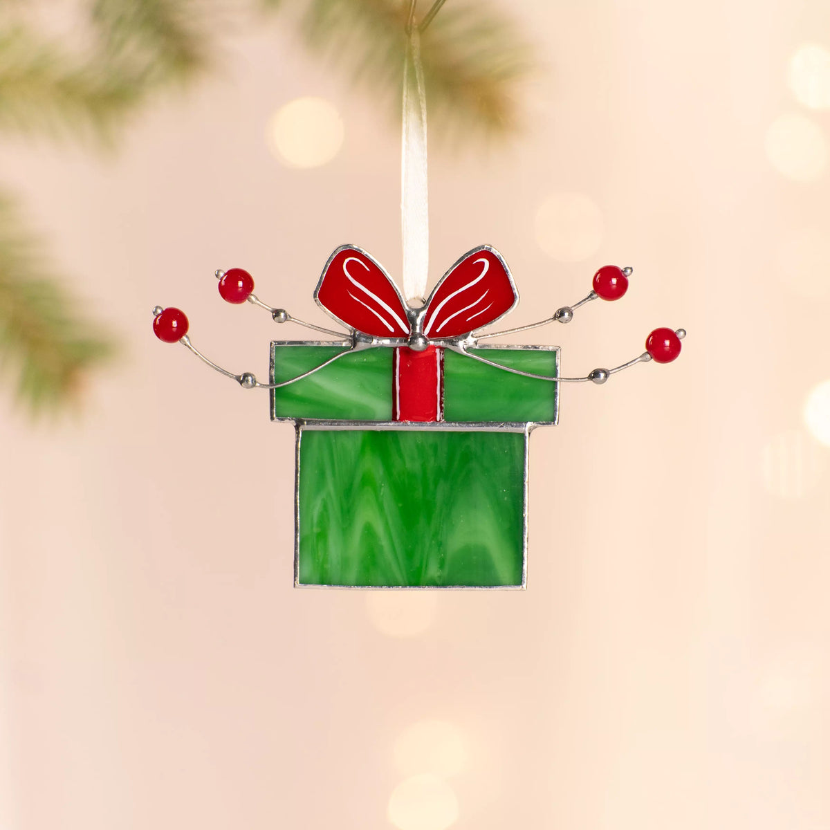Stained glass suncatcher green gift box with a red ribbon, decorated with red beads and silver wire.