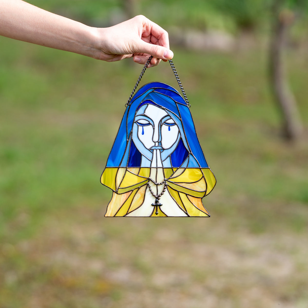 Stained glass praying and crying woman symbolising Ukraine window panel