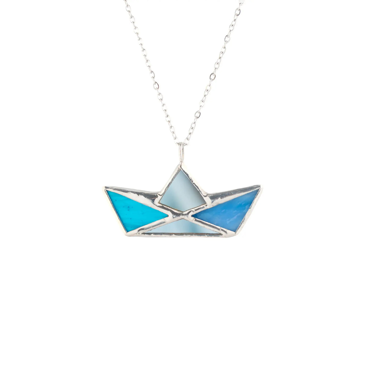 Blue Boat stained glass necklace on a white background - a handmade paper-boat pendant in shades of blue glass with mirror details and silver seams on a slim chain, nautical jewelry and a gift for boat lovers
