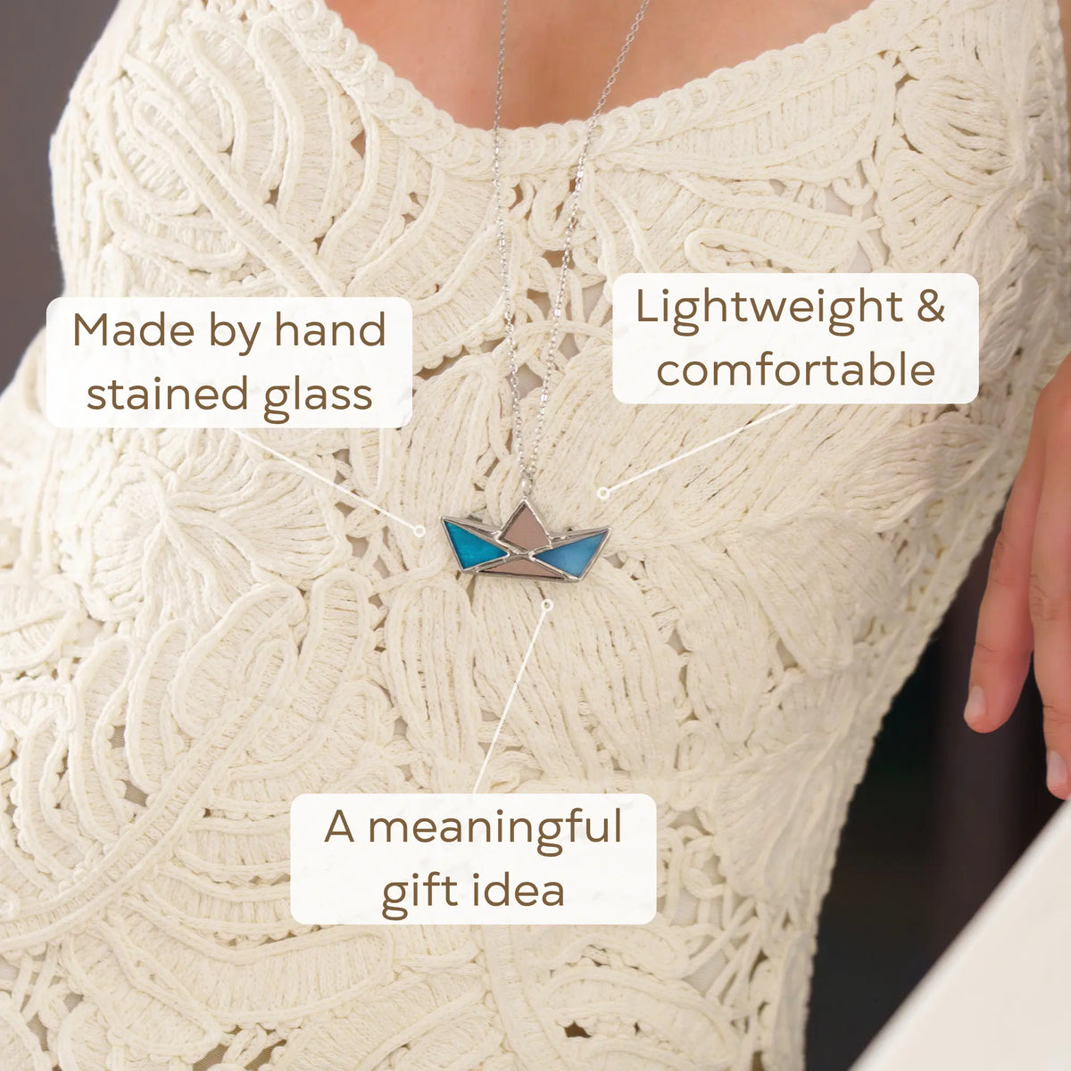 Woman wearing the Blue Boat stained glass necklace over an ivory lace dress - a handmade stained glass boat pendant with sun-catching mirror accents that makes a meaningful gift idea