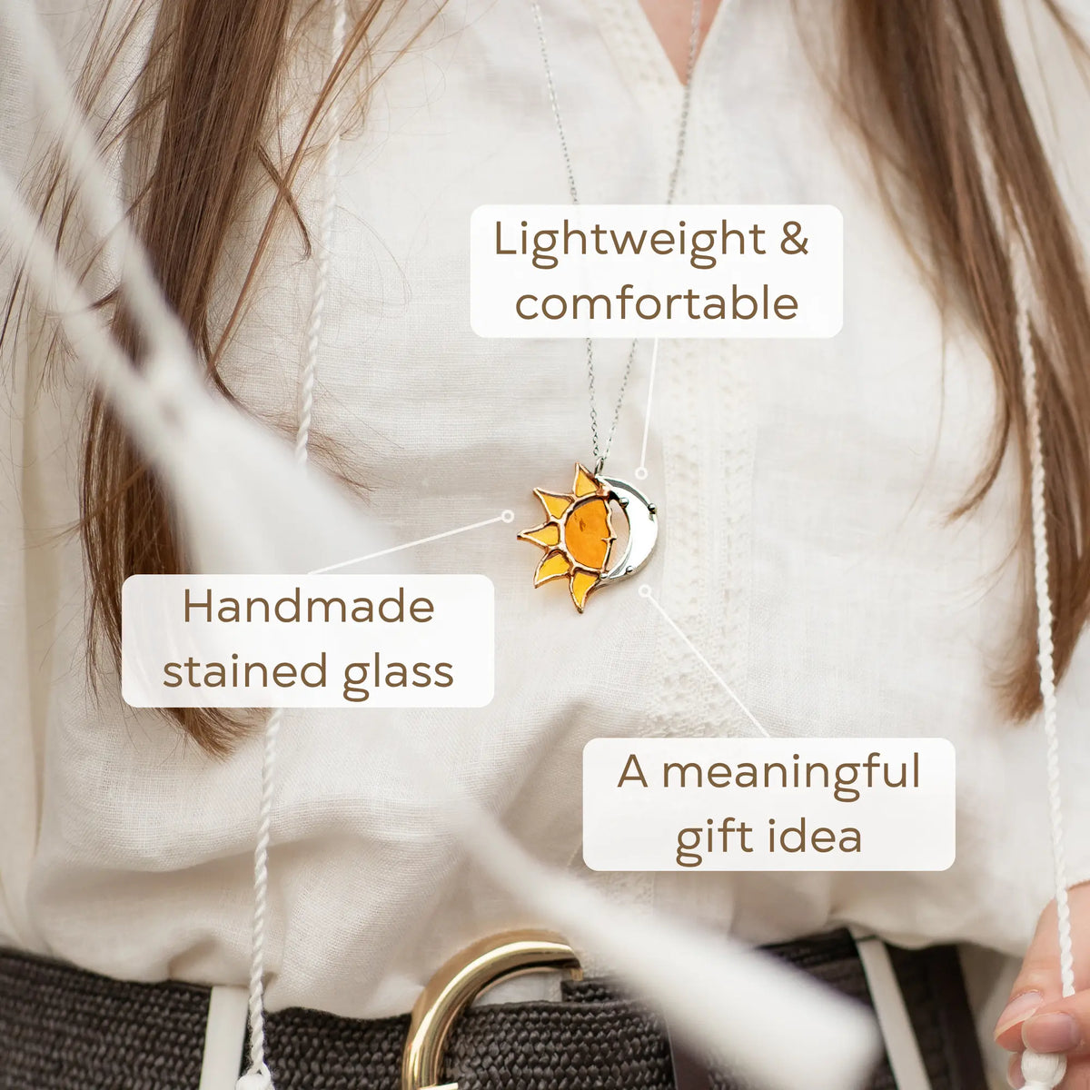 Close-up of the handmade stained glass sun and moon pendant - warm amber sun glass and a reflective silver crescent moon on a delicate silver chain, a celestial gift for her