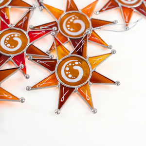 A close-up of stained glass Christmas star-shaped ornaments 