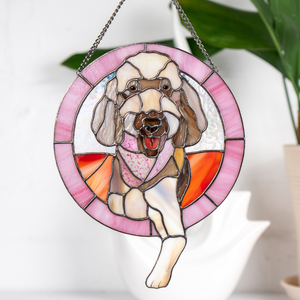 A stained glass window hanging featuring a dog in a circular frame