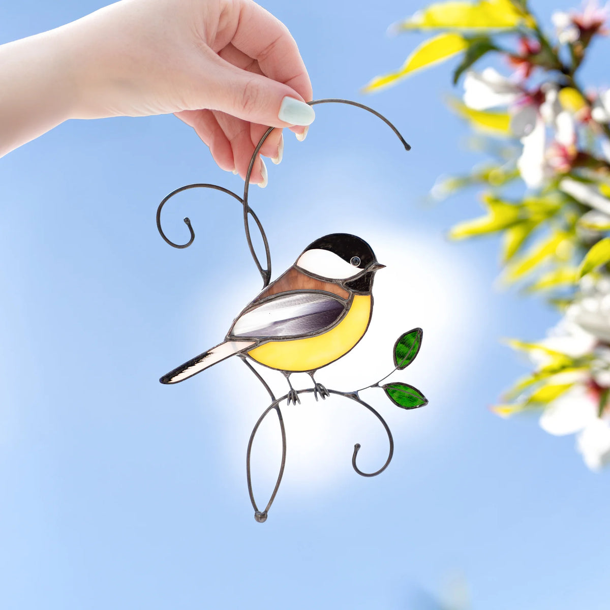 Stained glass chickadee suncatcher hold in hand - handmade black-capped chickadee on a wire branch with green leaves
