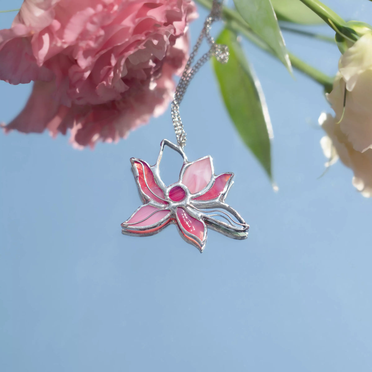 Handmade stained glass pink lotus necklace worn on a long silver chain - a pink lotus flower pendant, nature-inspired botanical jewelry and a gift of new beginnings