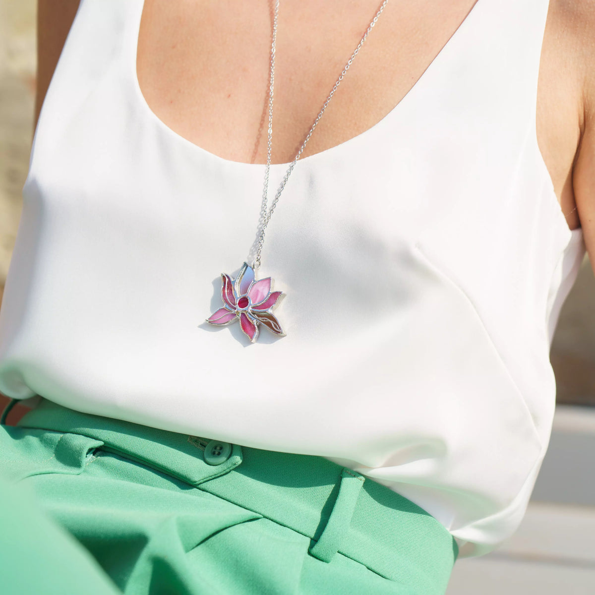 Handmade stained glass lotus necklace - a soft pink lotus flower pendant catching the light on a fine chain, a symbol of purity and rising above