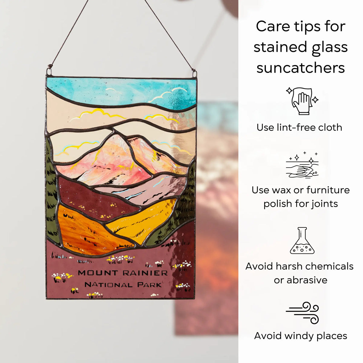 Stained glass suncatcher with mountain design and care tips on the right: use lint-free cloth, polish joints with car wax or furniture polish, avoid harsh chemicals, and windy places.