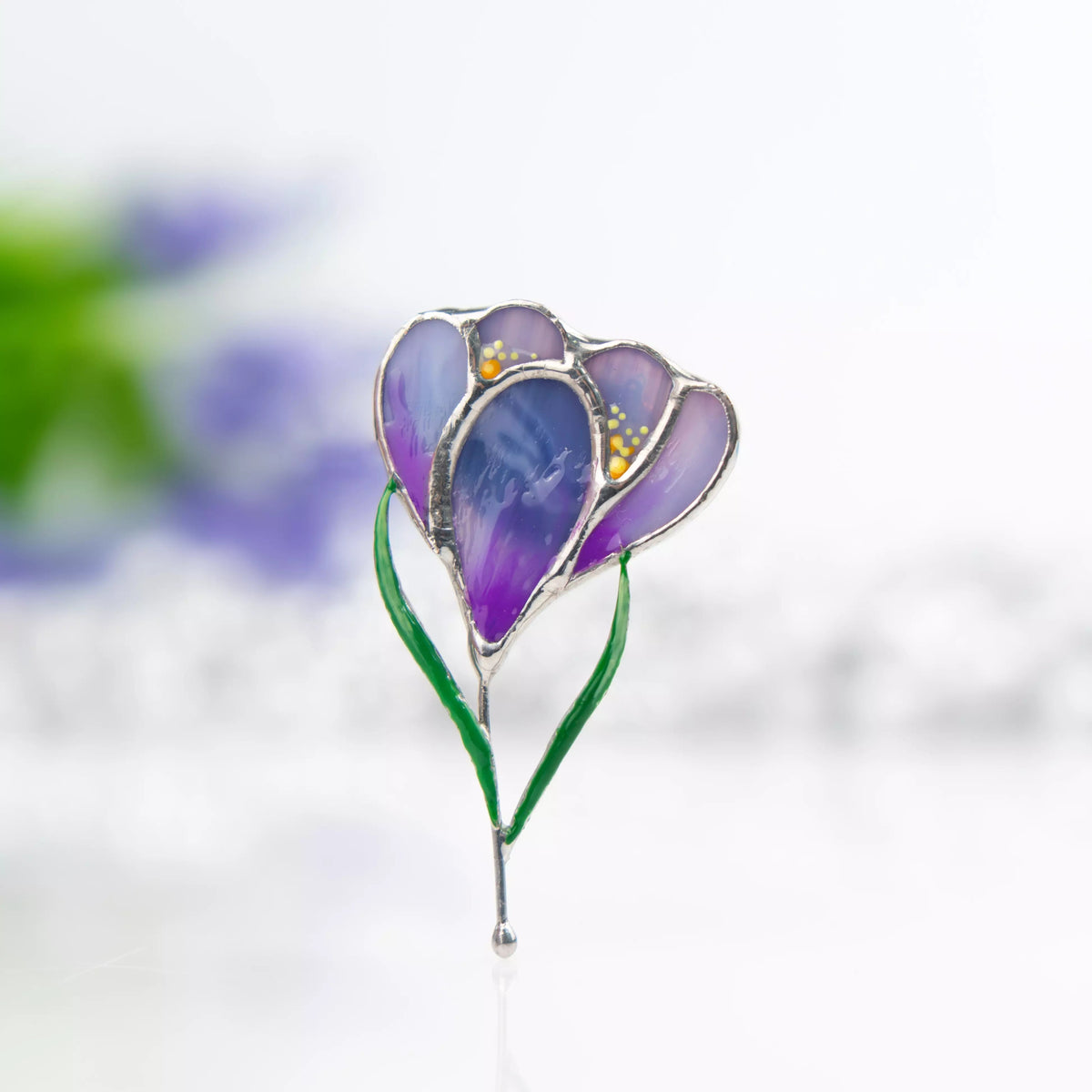 Stained glass brooch purple crocus flower with green stem on a white background
