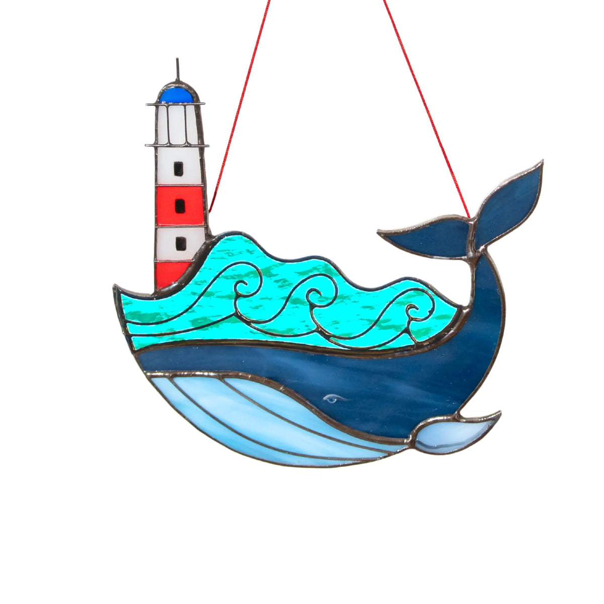 Stained glass whale with a lighthouse suncatcher on a white background