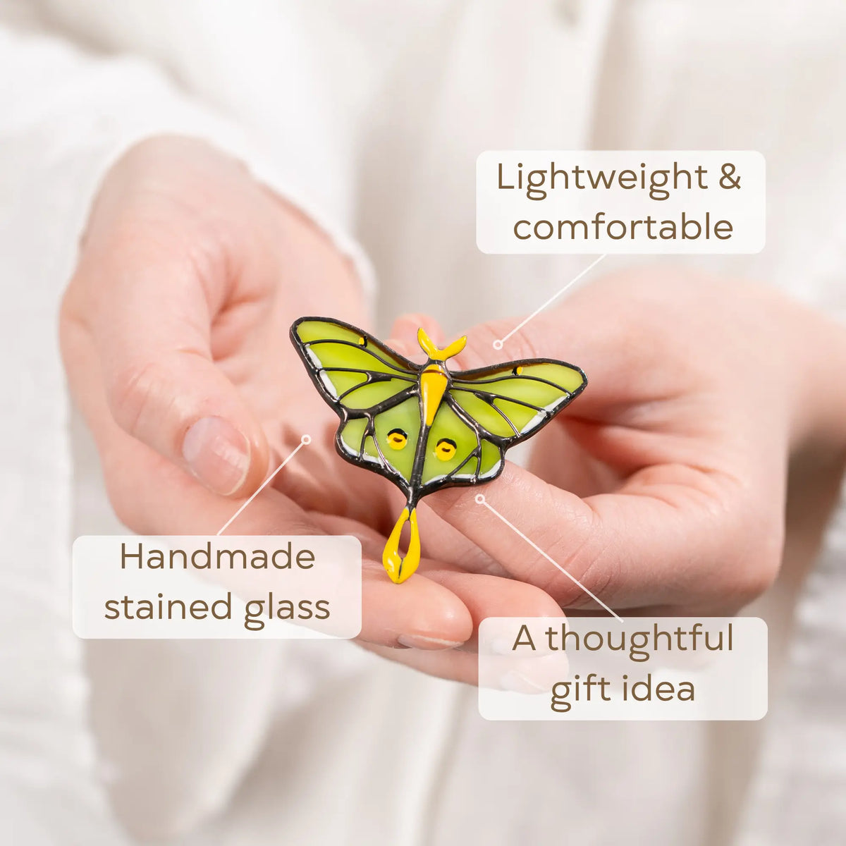 Hand holding a green luna moth butterfly stained glass piece as a thoughtful gift idea