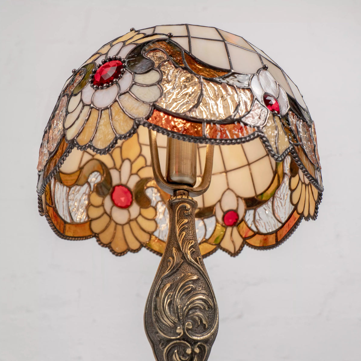 Inside view of stained glass lamp showing light bulb, wiring, and vibrant floral design