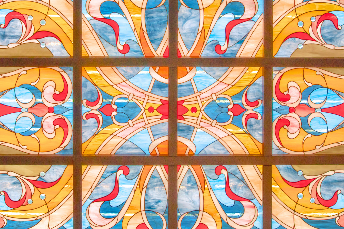 A colorful stained glass window with symmetrical, ornate patterns  