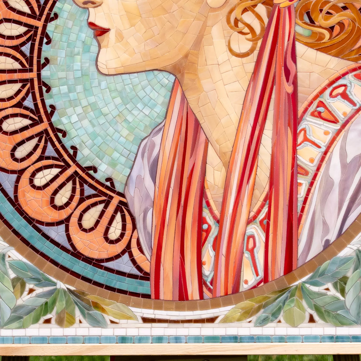 Art Nouveau style mosaic of a woman's face with intricate patterns and colors.