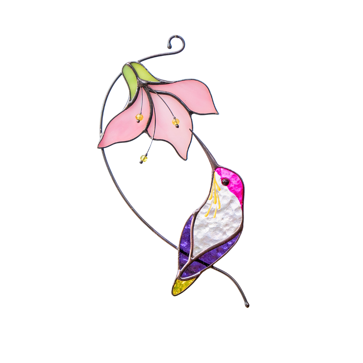 A stained glass suncatcher showing a hummingbird with purple wings and a bright pink flower, hanging in sunlight.