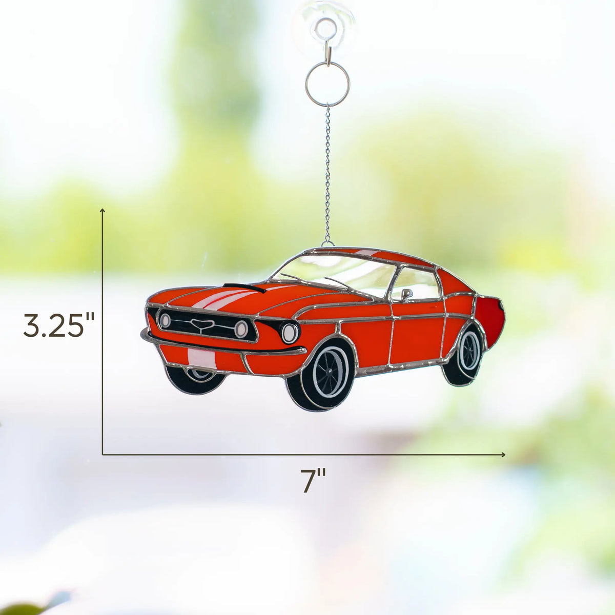 Red car-shaped stained glass ornament with dimensions 3.25 x 7 inches on a blurred background