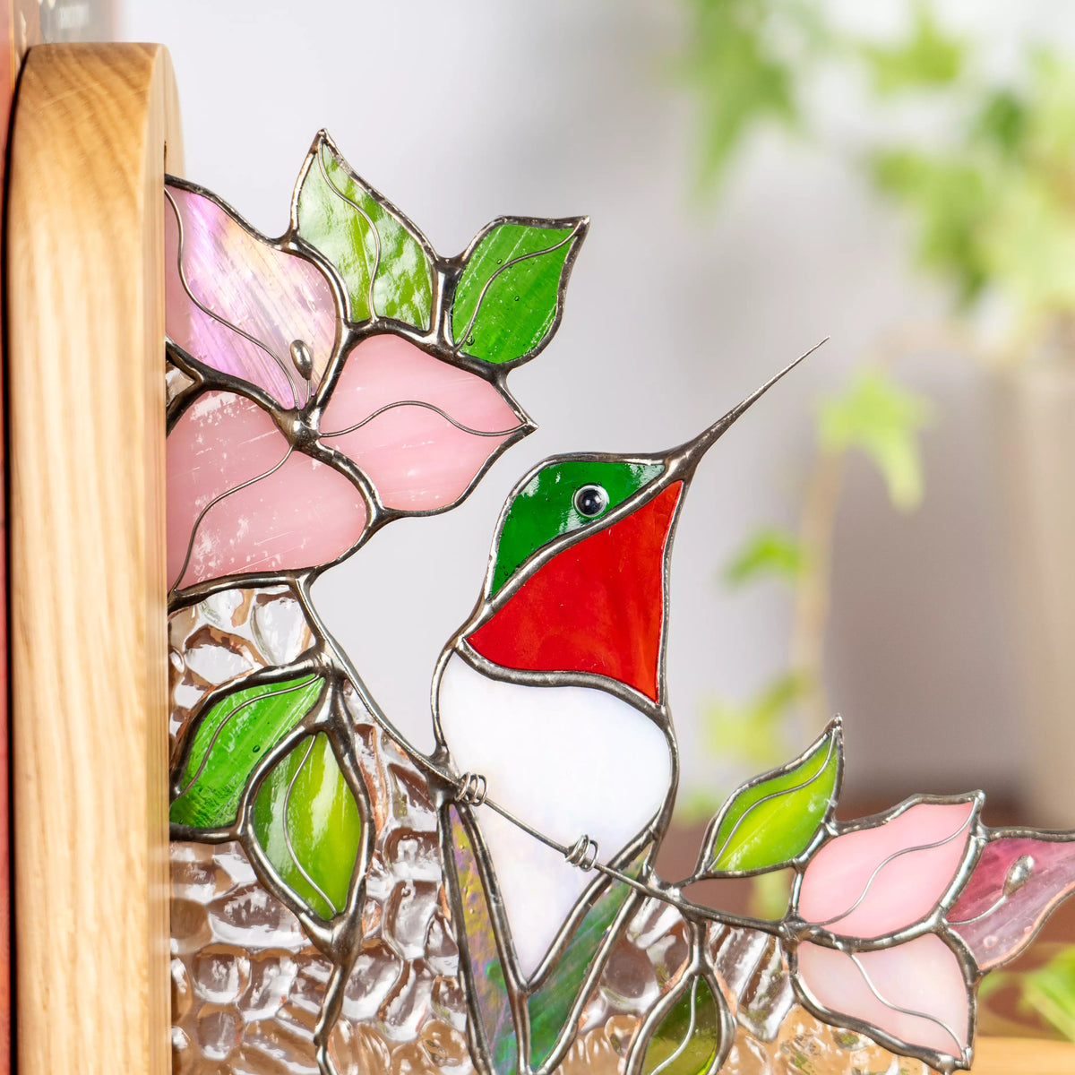 Stained glass hummingbird bookend featuring a red and green bird among pink glass flowers.