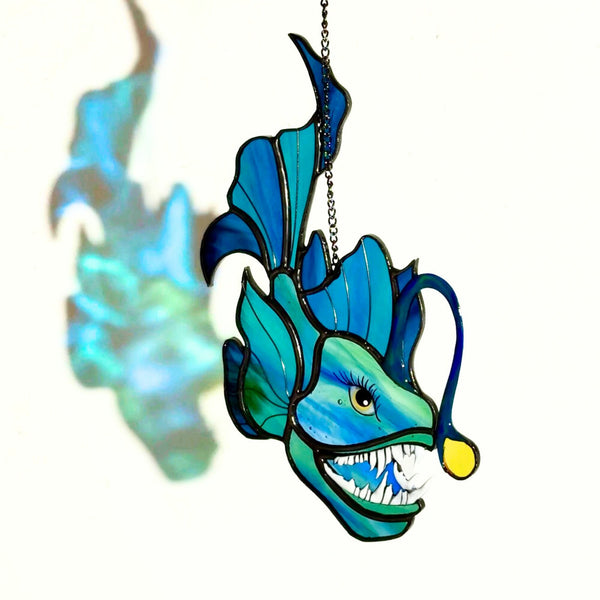 Decorative fish ornament with blue and green colors on a white background