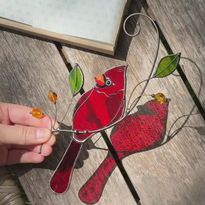 Stained glass cardinal perched on a branch with green glass leaves  suncatcher 