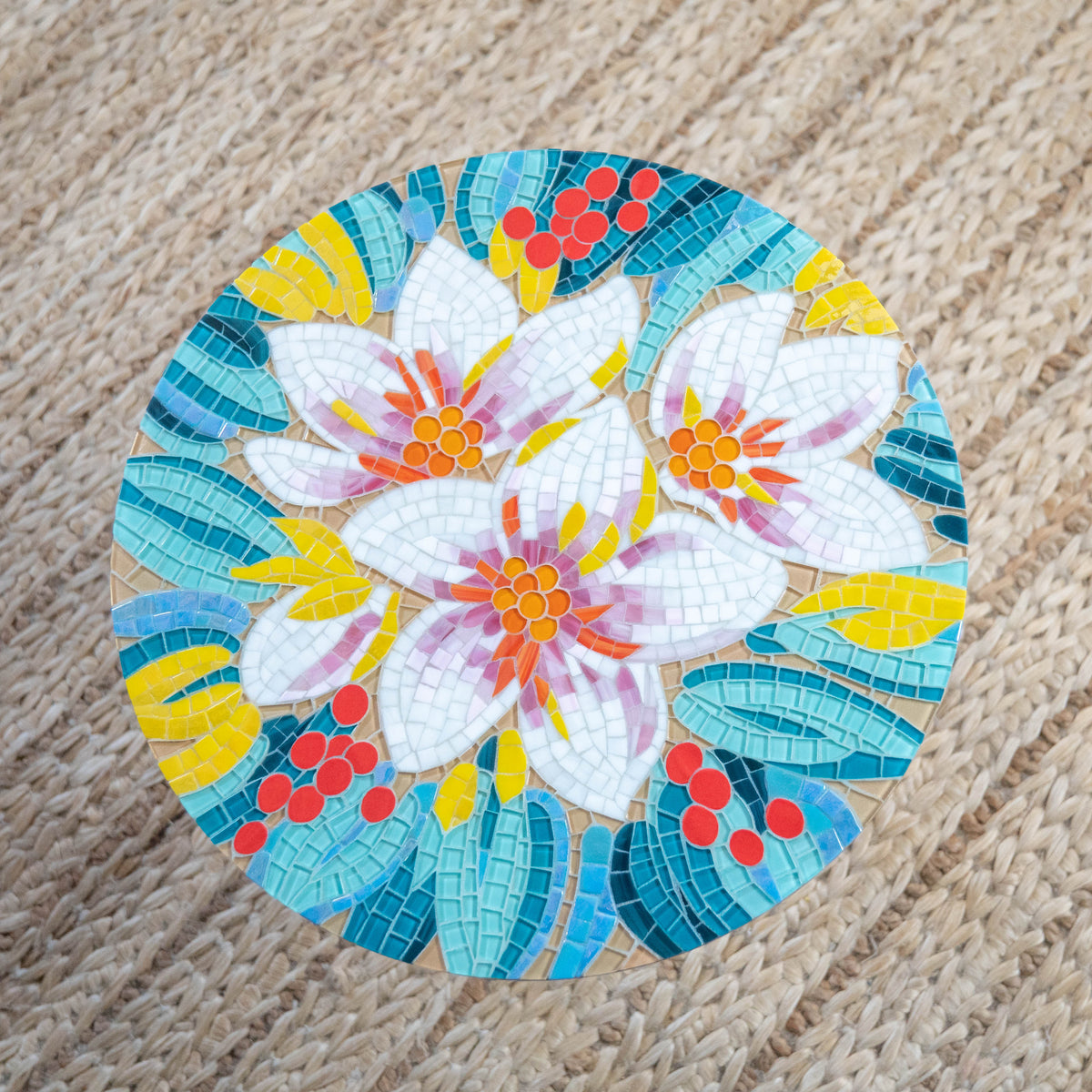 Round mosaic table of stained glass depicting white and pink leaves