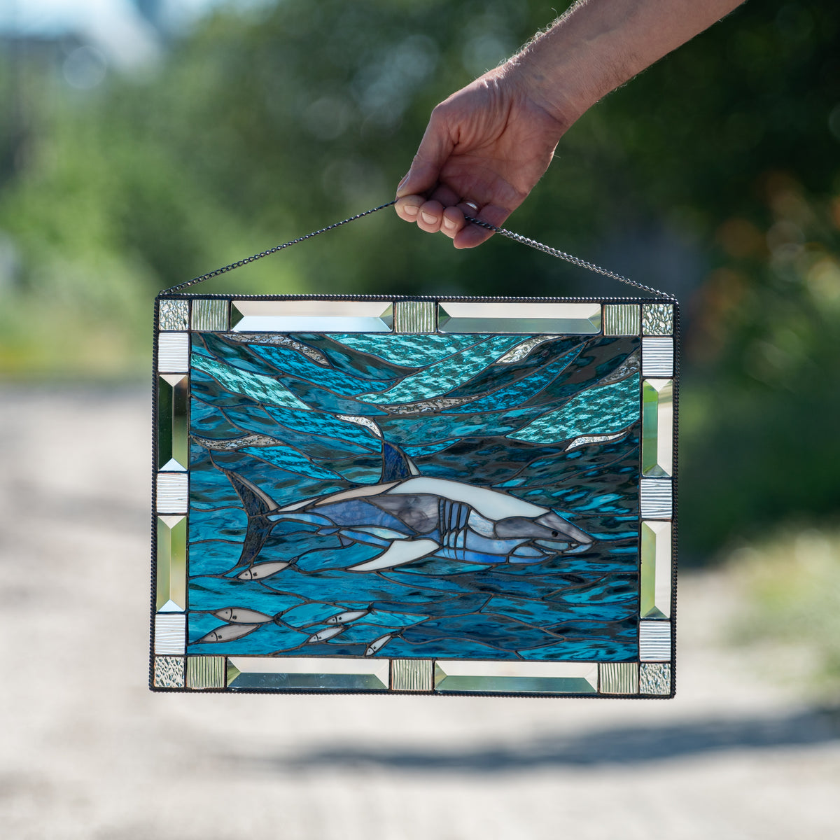 Stained glass panel depicting shark in the water 
