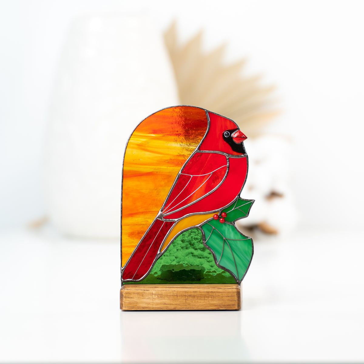 Zoomed candle-lit cardinal with the leaf stained glass panel