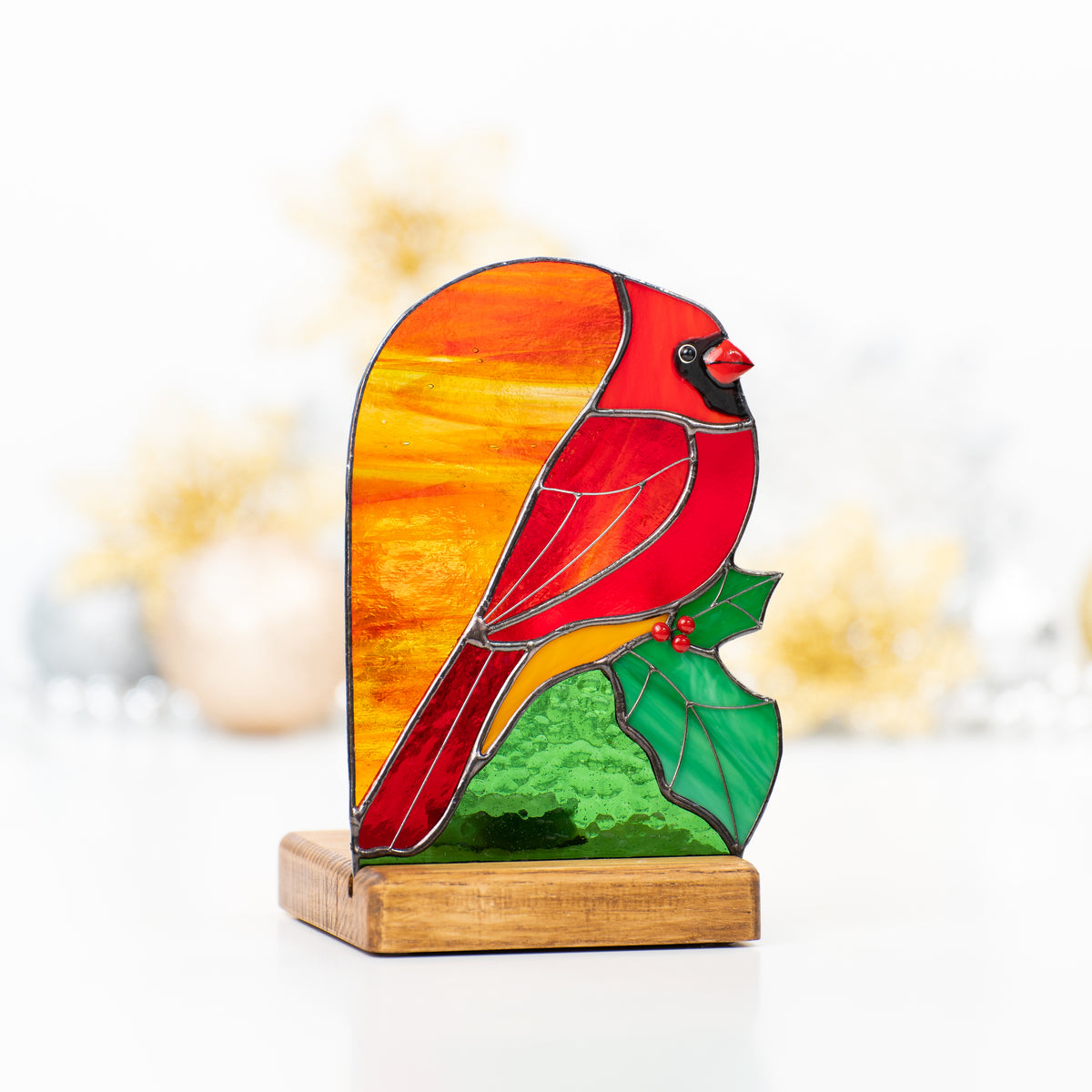 Candle-lit red cardinal panel of stained glass in a wooden base